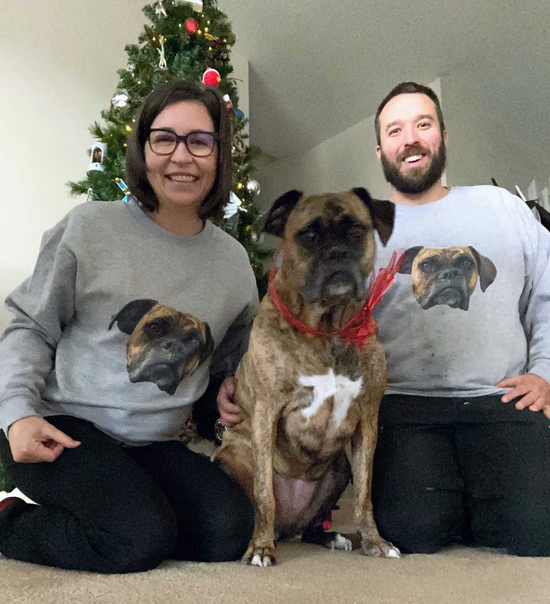 Couple wearing matching My Pets Face sweatshirts with their beloved boxer dog